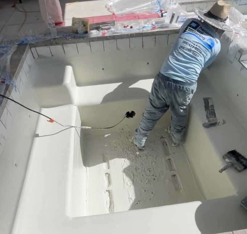 Quartz plaster pool finish being applied — Phenomenal Pool & Landscape crew at work